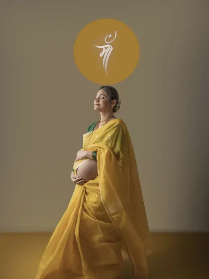 A serene solo portrait of the mother to be in her yellow saree, eyes closed in peaceful contemplation. The 'Maa' symbol above her head beautifully completes this tribute to motherhood.