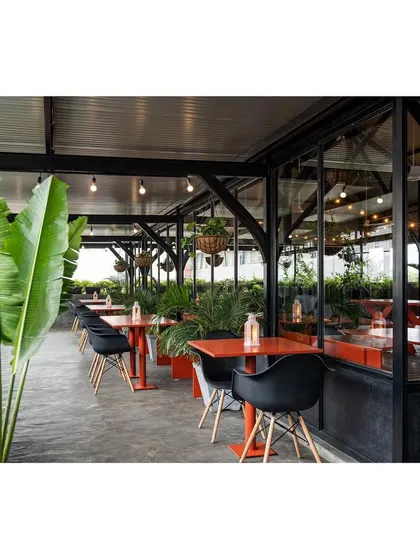 The terrace seating area is separated from the interior by glass walls, providing a weather-proof option without sacrificing the view. This practical design consideration ensures the space is usable year-round for various corporate and private functions.