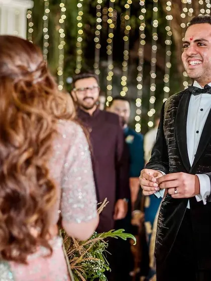 The groom's happy and relieved expression after the playful ring prank, looking at his bride.