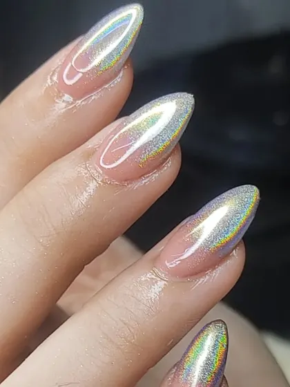 A close-up of a stunning holographic chrome finish on almond-shaped nails. The way the light reflects a rainbow of colors is absolutely mesmerizing.