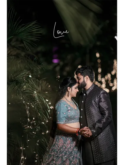 An intimate and romantic portrait of the couple at their evening reception, framed by palm leaves and soft lights.