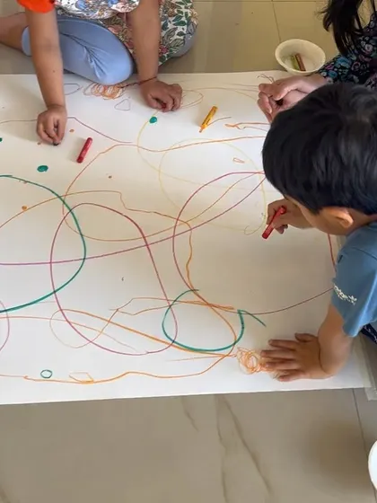 Another angle of our collaborative drawing session. This activity helps develop social skills as children learn to share tools and space, all while contributing to a single, large-scale piece of art.