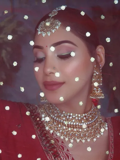 The beauty behind the veil. This shot captures the soft, glowing makeup under a delicate dupatta, a dreamy and classic bridal portrait.