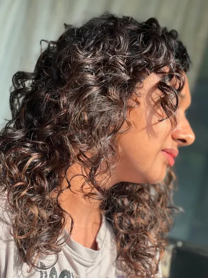 A close-up of the sunlit curls, highlighting the beautiful shape and definition we achieve with our cutting techniques.