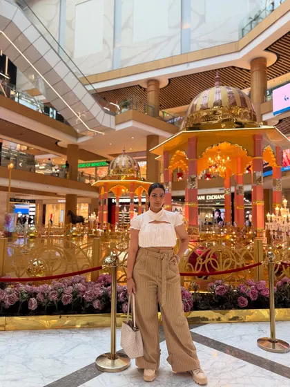 A neutral-toned outfit perfect for a day at the mall. A white cut-out top paired with beige wide-leg trousers and platform sneakers.