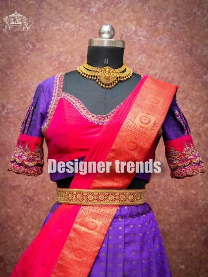 A close-up of the purple and red pattu langa voni, highlighting the detailed embroidery on the blouse sleeves.
