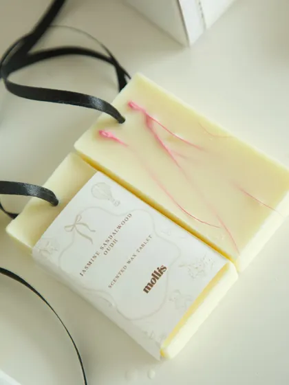 A detailed shot of a scented wax tablet with a delicate pink swirl, part of a custom baby shower gift.