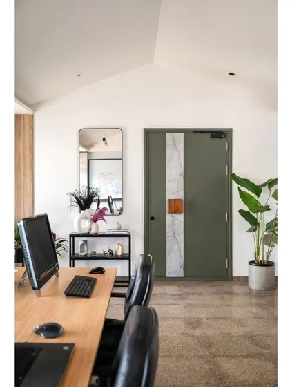 The entrance to the Project Rooftop office, seen from a workstation. The gabled ceiling and custom green door create a unique and inspiring view. I believe your workspace should be filled with details that you love to look at every day.