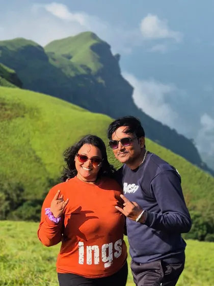 A couple having fun on the Bandaje trail, with the beautiful green hills behind them.