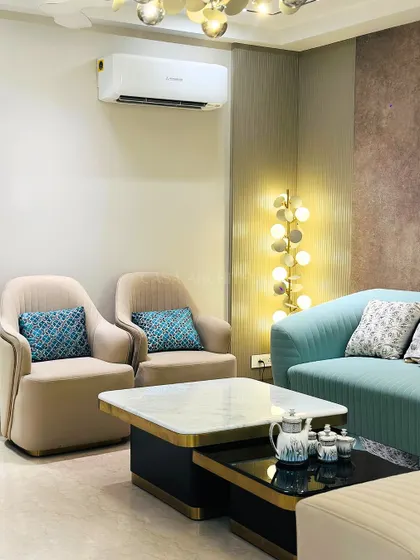 This living room corner showcases a mix of seating options, including two beige armchairs and a light blue sofa, creating a versatile space for conversation.