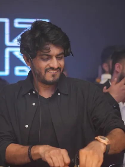 Checking the time and the mix at Striker. A candid moment showing the multitasking and focus required during a live set.
