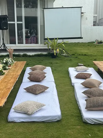 A clear view of the low seating arrangement for the movie night party, with mattresses, cushions, and low wooden tables.