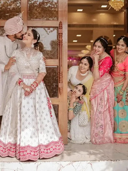 A sweet kiss on the cheek while the bridesmaids playfully look on. We love capturing these fun, interactive moments that involve the whole wedding party.