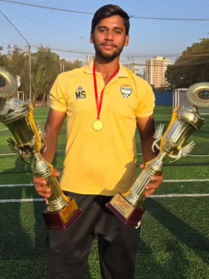A coach proudly displays two championship trophies. We celebrate the hard work of our staff who make these wins possible.