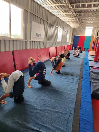 A group of students working on their headstands during a floor session, building strength and balance.
