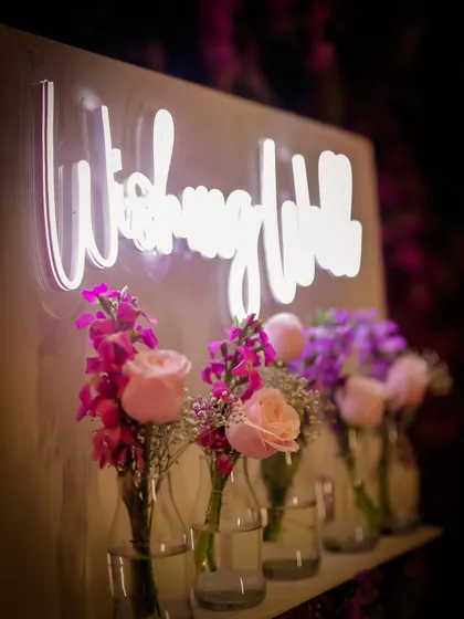 A close-up of the "Wishing Well" neon sign. The soft glow adds a modern and romantic touch to this interactive guest activity.