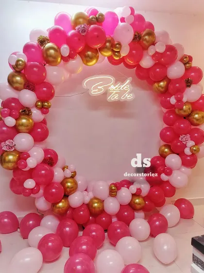 This full-ring balloon backdrop is one of our most requested items for bridal showers. We created this look with a vibrant mix of pink, white, and gold balloons, centered around a custom 'Bride to be' neon sign for the perfect photo opportunity.