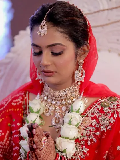 A serene moment of prayer during the wedding ceremony. Her soft glam makeup, with its warm tones and gentle shimmer, looks elegant and timeless, perfectly suited for the solemnity and joy of the occasion.