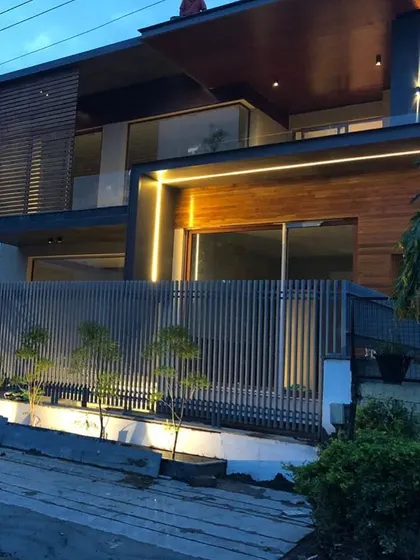 For this home, I used a bold vertical line of light to contrast with the horizontal wooden slats and fence. This technique adds visual height and a strong design element to the building's exterior.