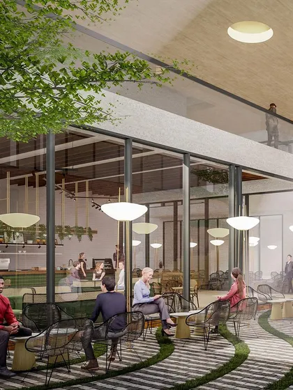 The café and seating area within the Myhome Vipina Clubhouse. This open, airy space is designed to feel like a part of the landscape, with indoor trees and paving that blurs the line between inside and out.