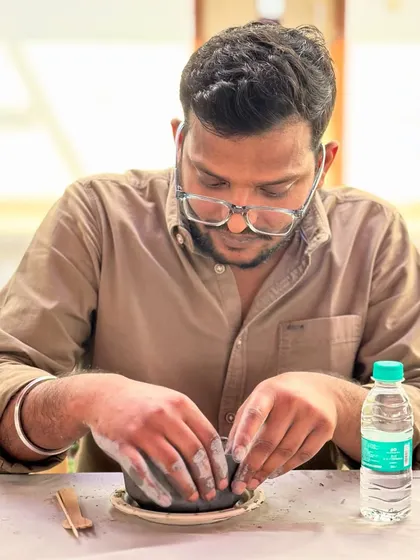 Trading hypotheses for handprints. This scientist is completely absorbed in the tactile process of moulding his first piece of pottery.
