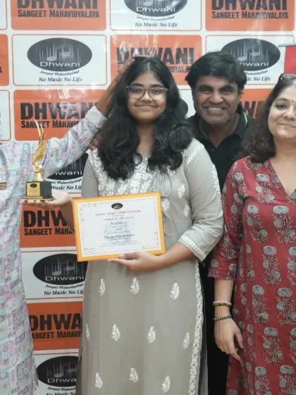 A student with her parents and teacher, a complete support system.
