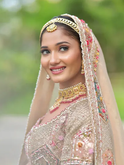 A soft, glowing look for this bride in a beautiful pastel outfit. The makeup is minimal and elegant, letting her natural beauty shine.