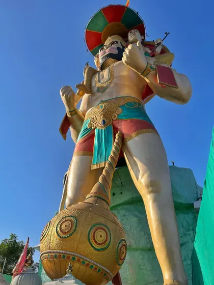A low-angle shot emphasizing the immense size of the Lord Hanuman statue.