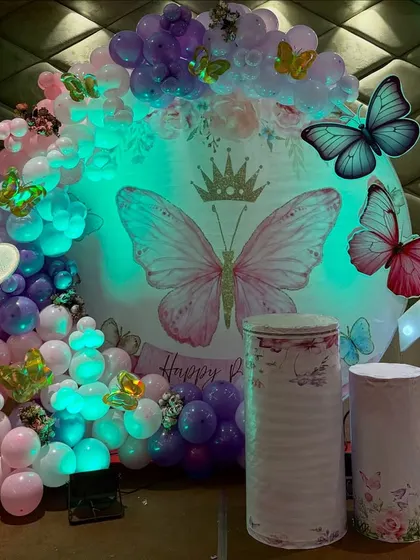 The lighting can completely change the mood of the decor. Here's the same butterfly setup with a cool-toned light, highlighting the purple and blue shades in the balloon arrangement.