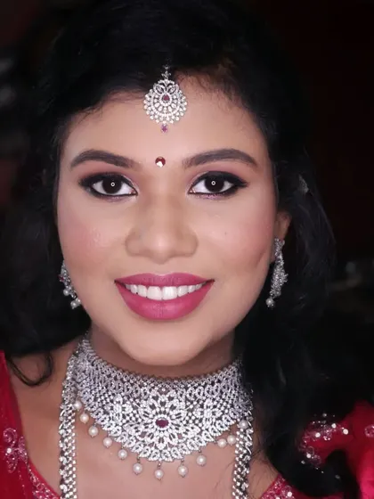 A beautiful smile from Kusuma on her engagement day. Her makeup is glamorous yet elegant, with a shimmery eyeshadow and a bright pink lip that lights up her face.