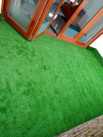 This high-angle view demonstrates the complete coverage of the artificial turf, turning the entire balcony into a single, cohesive green space.