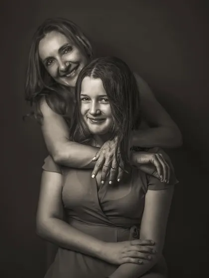 A duplicate of image 95, this monochrome portrait captures the beautiful bond between a mother and her teenage daughter. Their genuine smiles and close embrace tell a story of love and connection that transcends time.