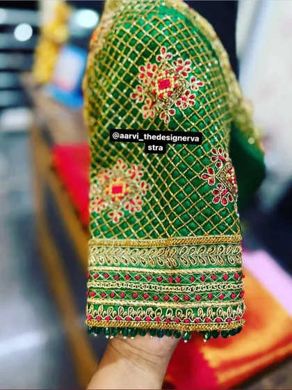 A close-up of the sleeve of the 'baraat' blouse, showing the intricate lattice work and floral motifs.