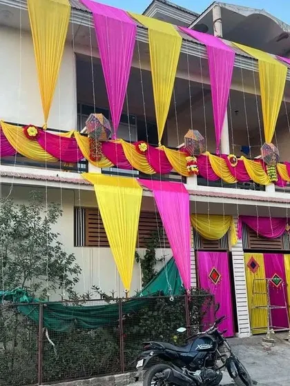 The same house decoration seen during the day, showcasing the vibrant pink and yellow fabric against the building's exterior.