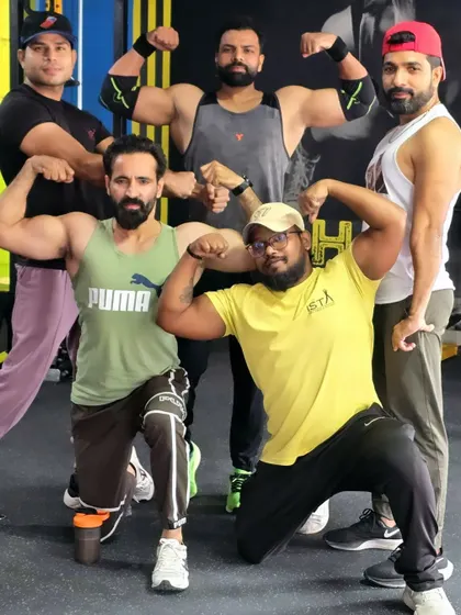 Strong people don't put others down, they lift them up. Our team of trainers and dedicated members flexing together.
