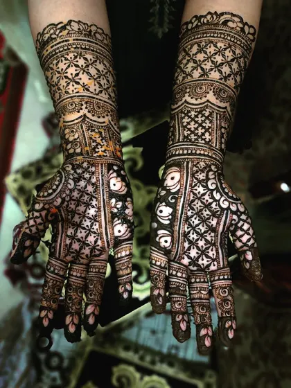 This design features a striking fish motif, a symbol of fertility and good fortune, on the palms. The rest of the hands are covered in a heavy, grid-like pattern for a bold and unique bridal style.