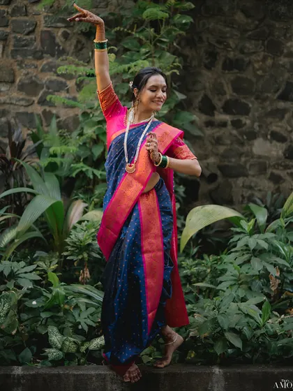 We see the art in tradition. For this bridal portrait, we incorporated the bride's passion for Bharatnatyam, capturing her grace in a classic dance pose against a lush, natural backdrop.