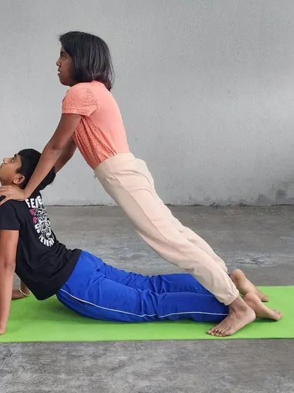The focus in this partner-assisted cobra pose is beautiful, showing how we guide campers to achieve deeper, safer stretches.