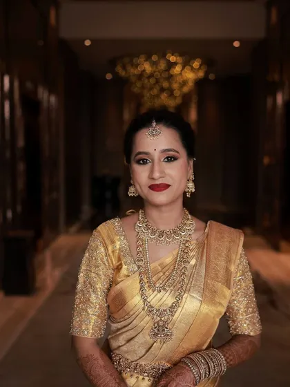 A stunning portrait of a bride in a golden Kanchipuram saree. I created a classic look with a bold red lip and soft golden eyes to match her all-gold theme, resulting in a radiant and luxurious bridal style.