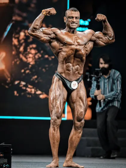 The Front Double Biceps is a game-changer. It displays the complete muscularity, conditioning, and symmetry of your physique. This is me on stage, hitting the pose with the confidence and technical precision that I teach all my clients.