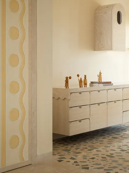 A detail from our Soft Serve project, showing a custom floating credenza with a scalloped edge and a wall-mounted cabinet with an arched top.