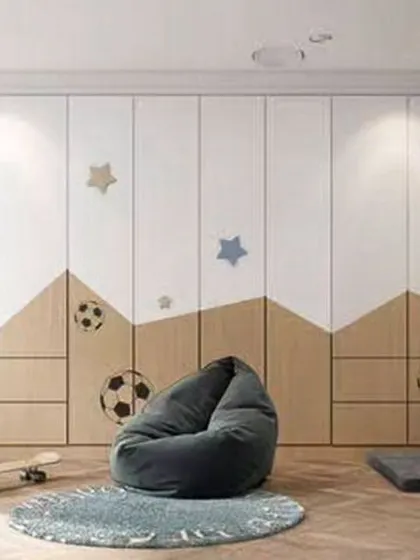 This sports-themed room features a full wall of custom wardrobes with a mountain and soccer ball motif. The open space is perfect for play, with a soft beanbag for relaxing.