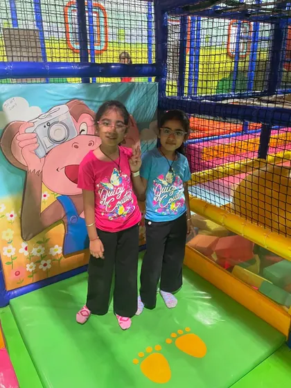 Two friends posing for a picture inside the play maze. The colorful backdrops make for great photo opportunities.