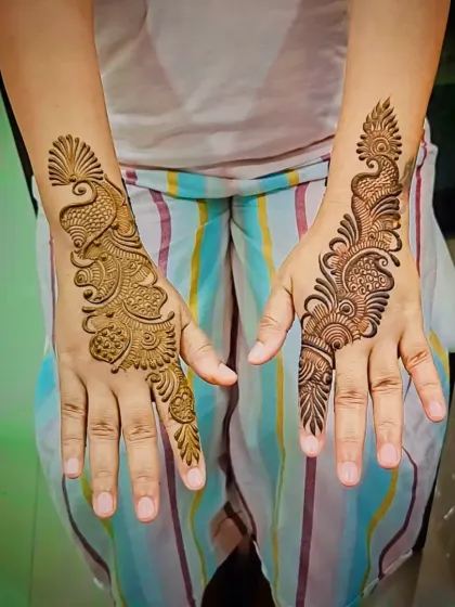 A simple yet elegant Arabic design, featuring a classic peacock-inspired trail on the back of the hand. This is perfect for a minimalist look.
