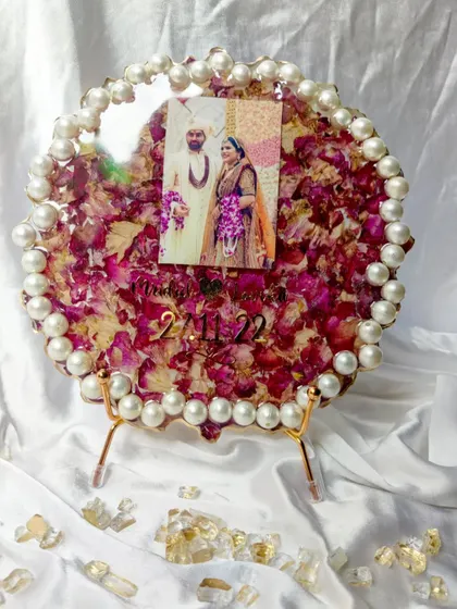 This pearl-bordered resin frame, displayed on a stand, is the perfect decor piece for any home. It holds not just flowers, but the cherished memory of a wedding day.