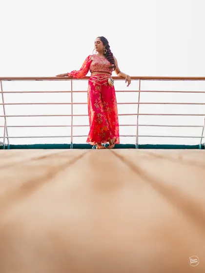 A creative low-angle shot of the bride on the wooden deck of the cruise ship, emphasizing her graceful presence against the open sky.