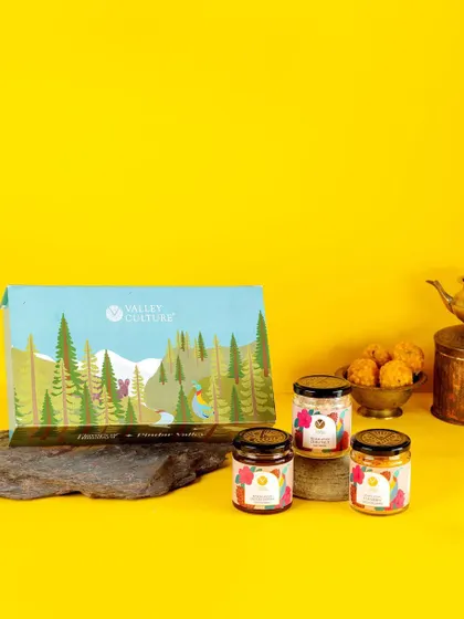A festive gift box from Valley Culture, photographed against a bright yellow background. This shot positions the brand's healthy products as a perfect gift option, combining wellness with celebration.
