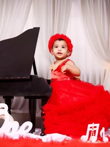A full view of the elegant red and white piano theme for a first birthday celebration.