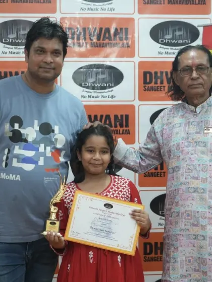 A student with her father and guru, celebrating her achievement.