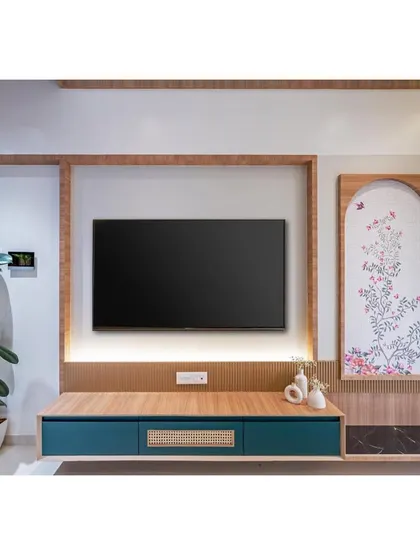 A minimalist TV unit with a beautiful hand-painted art panel beside it. The design combines clean lines with artistic, personal touches.